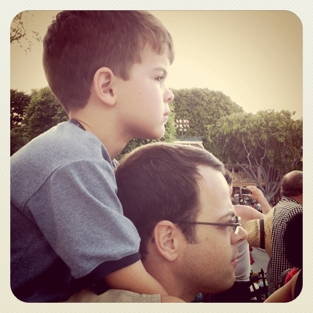 SPL riding his dad's shoulders watching the Disney parade.
